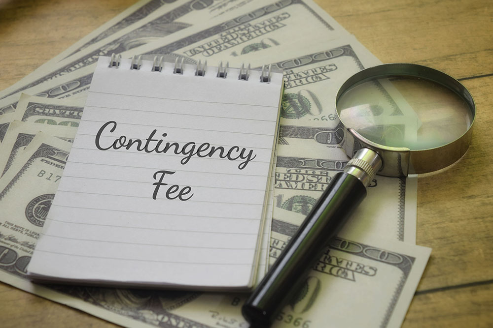 Contingency fee written on notepad with magnifying glass and cash