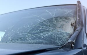 Shattered car windshield with severe crack damage after a hit and run accident in Missouri representing the type of vehicle damage handled by Cook Barkett Ponder and Wolz