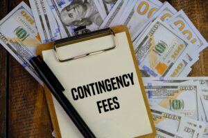 Contingency Fees written on a white paper with dollars in background