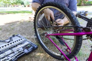 A man at work repairing the chain on his bike. 