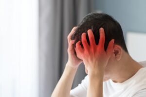 Chronic severe headaches and migraines caused by brain diseases. An adult male looks tired, stressed, and depressed, struggling with mental health issues.