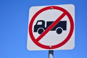 Isolated no heavy goods vehicles traffic sign and symbol against a blue sky background. 