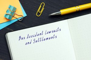 "Bus Accident Lawsuits and Settlements" written on a sheet of paper. 