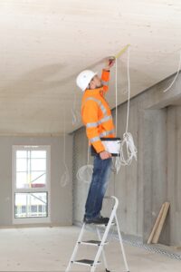 A construction worker standing at the defective ladder.