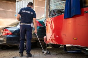 A police officer uses a measuring wheel to measure the distance at the scene of a car crash accident. Translation: "Police" 