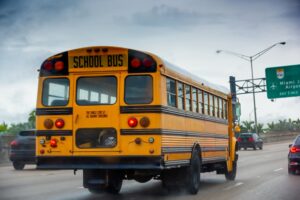 A school bus on the highway on a cloudy day in the USA.