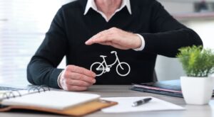 A man holds a bicycle on his desk