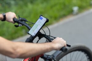 Man planning route using GPS navigation application in mobile phone on his bicycle