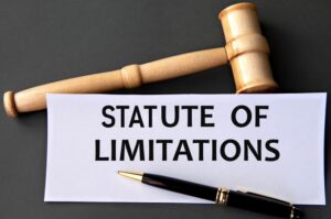 "STATUTE OF LIMITATIONS" written on white paper next to a judge's gavel, symbolizing legal authority and deadlines.