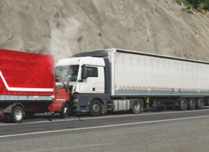 wo trucks involved in a head-on collision on the road, with visible damage to both vehicles