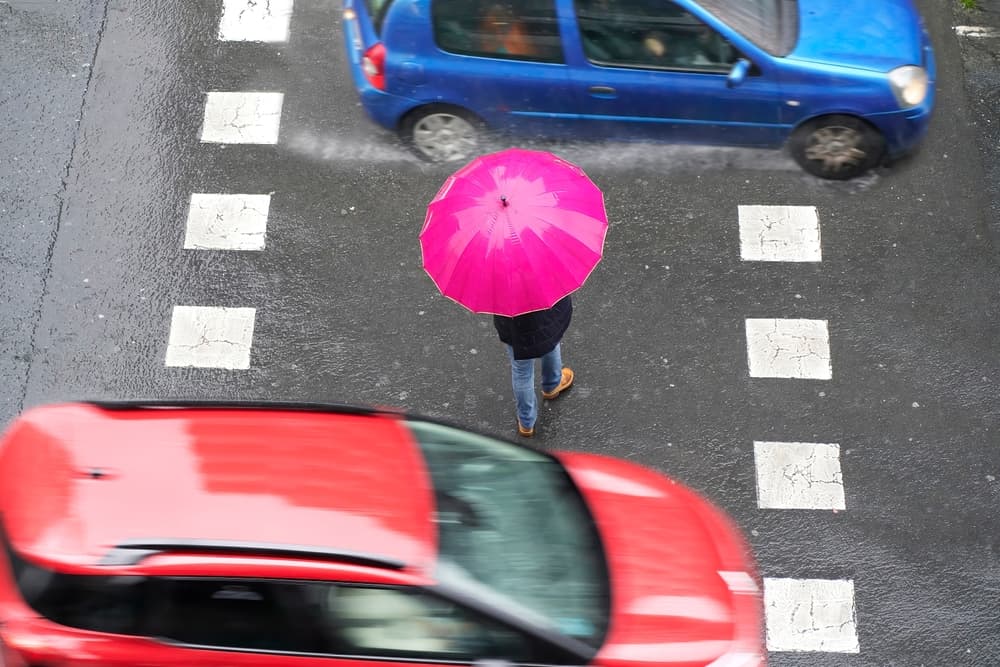 people pedestrian in dangerous situation in crosswalk in city street by vehicles at high speed.