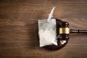 Judge gavel with a syringe, drugs, packet of heroin.