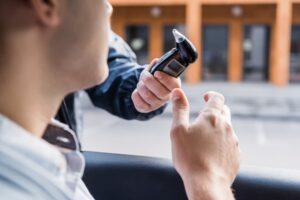 Policeman giving breathalyzer to driver in car, blurred foreground 