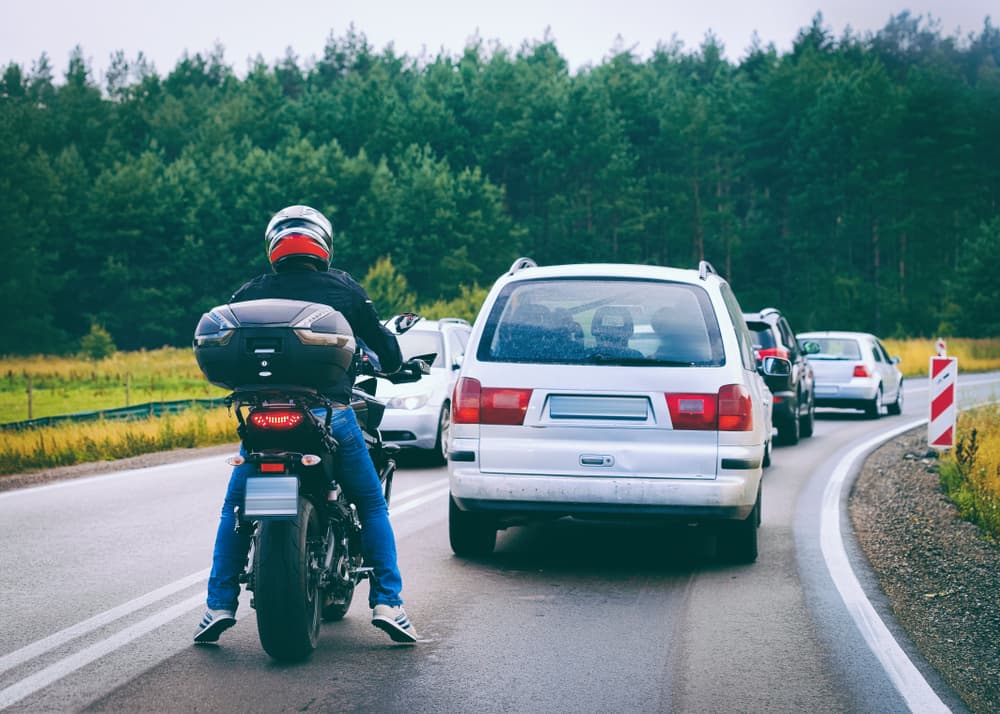 A motorcyclist passing car on the road
