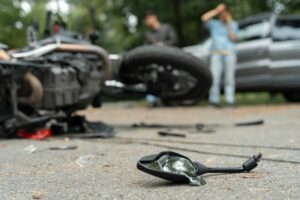 Damaged motorbike and car on the city road at the scene of an accident. Broken and wrecked motorcycle on road