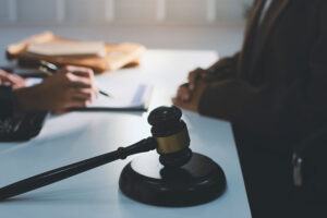 Attorney and client discussing documents at a desk with a gavel on the table.
