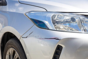 Close-up of car damage and scratches after a crash, representing repair costs and claim severity.