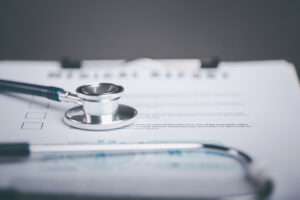 Medical report and stethoscope on a desk, representing documentation needed for an injury claim.