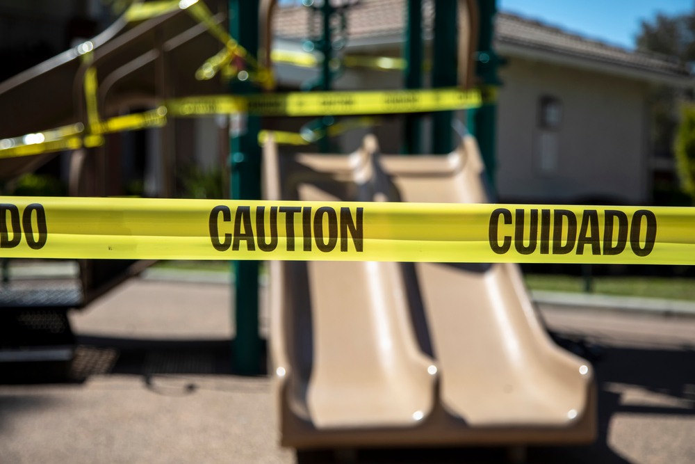 Yellow caution tape blocking access to a playground slide representing a dangerous property condition and premises liability claim in Missouri